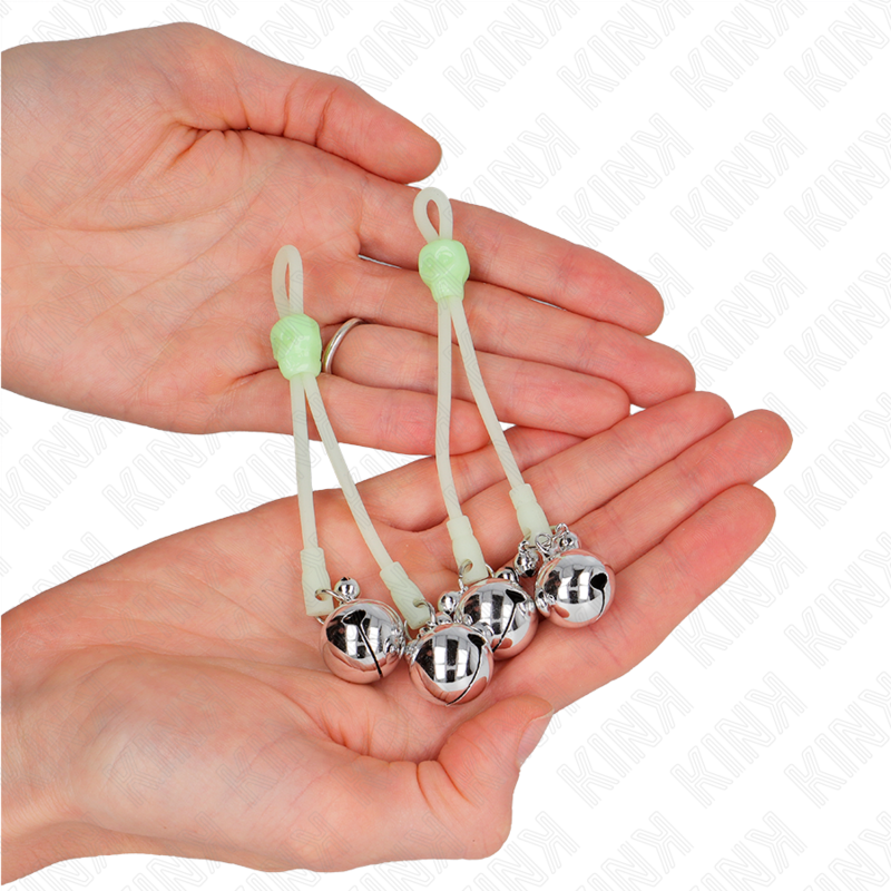 Close-up of the KINK Pinças para Mamilos Crânio Luminosas com Sinos Ajustáveis, showing luminous skull design and metal texture.