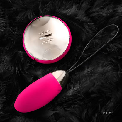 Detalhe do LELO Lyla 2 Insignia Oval Massageador em cor cerise com o seu controlo remoto, destacando o design elegante e a tecnologia SenseMotion™.
